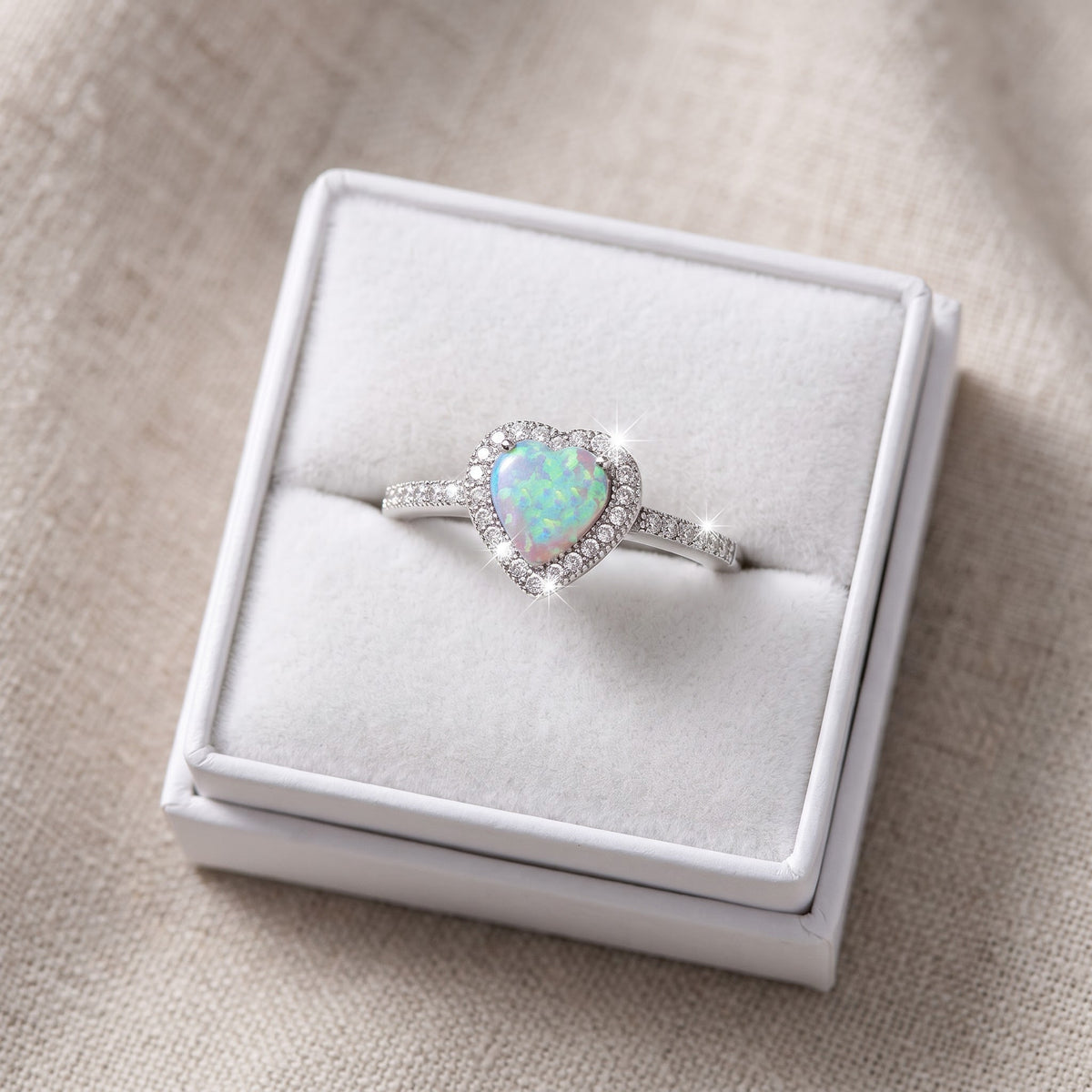 Sterling Silver Micro Pave Halo Created White Opal Heart Ring in a white gift box, ready to give