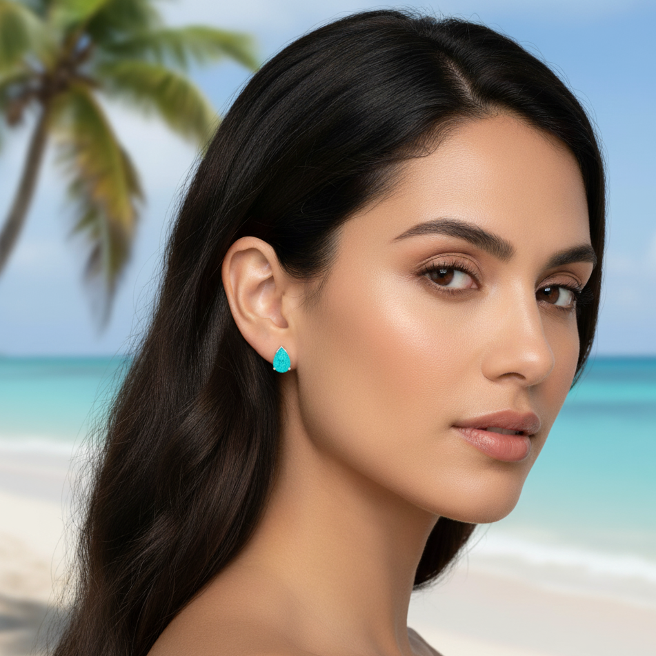 Woman wearing turquoise earrings with a beach background