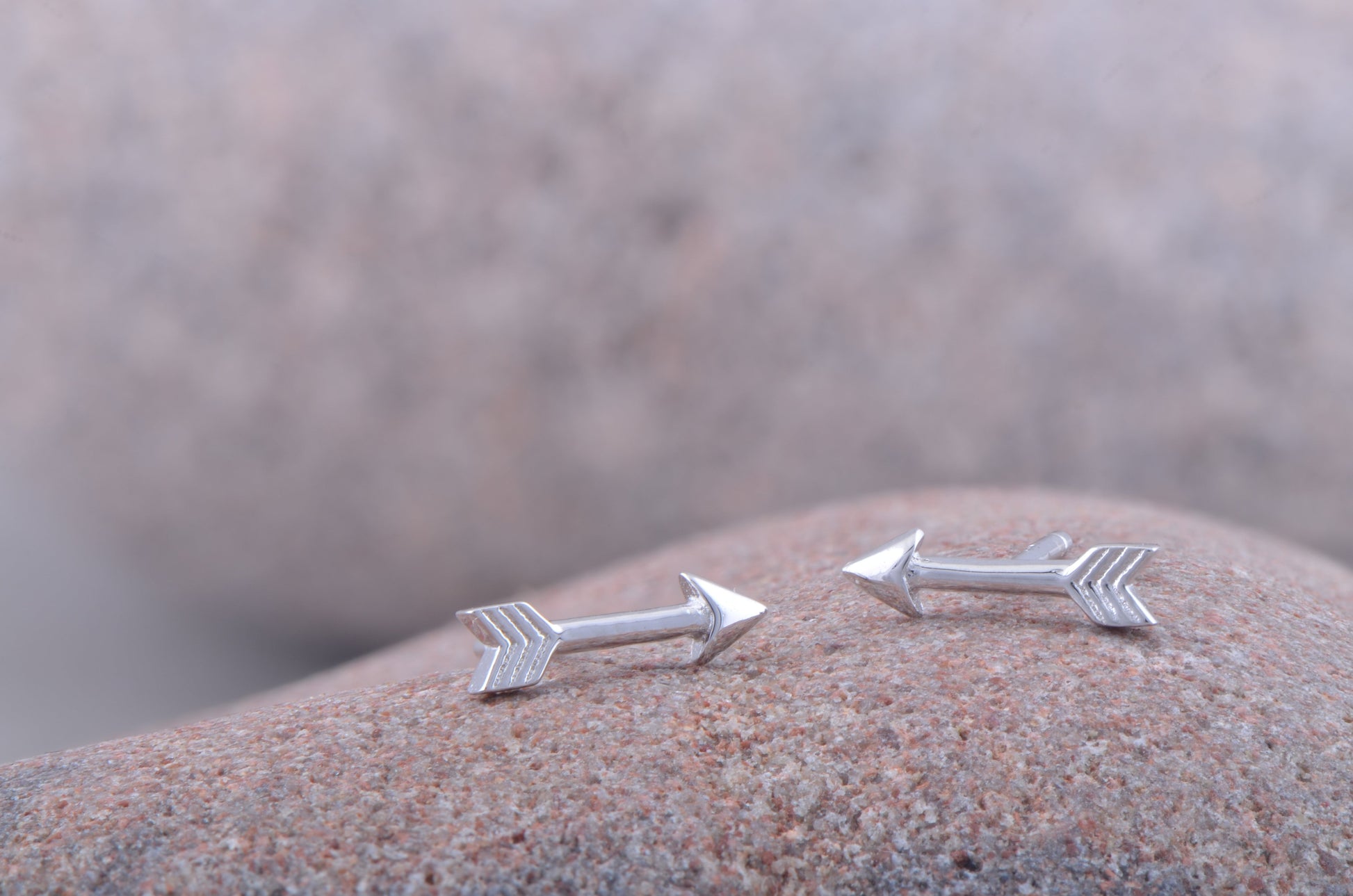 Sterling Silver Tiny Arrow Stud Earrings on stone