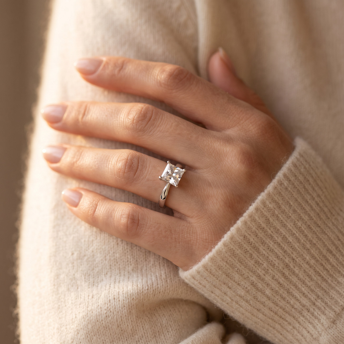 Sterling Silver Solitaire Princess Cut CZ Ring worn on a woman's hand in warm window light