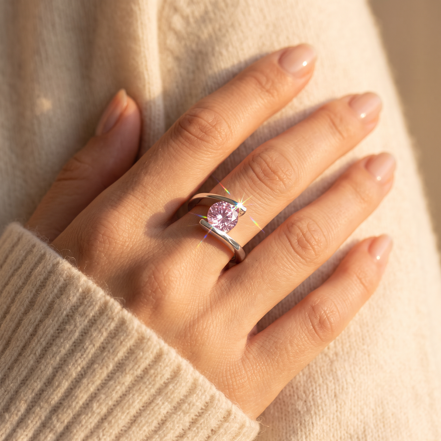 Sterling Silver Round Bezel Pink CZ Ring worn on a woman's hand in warm window light