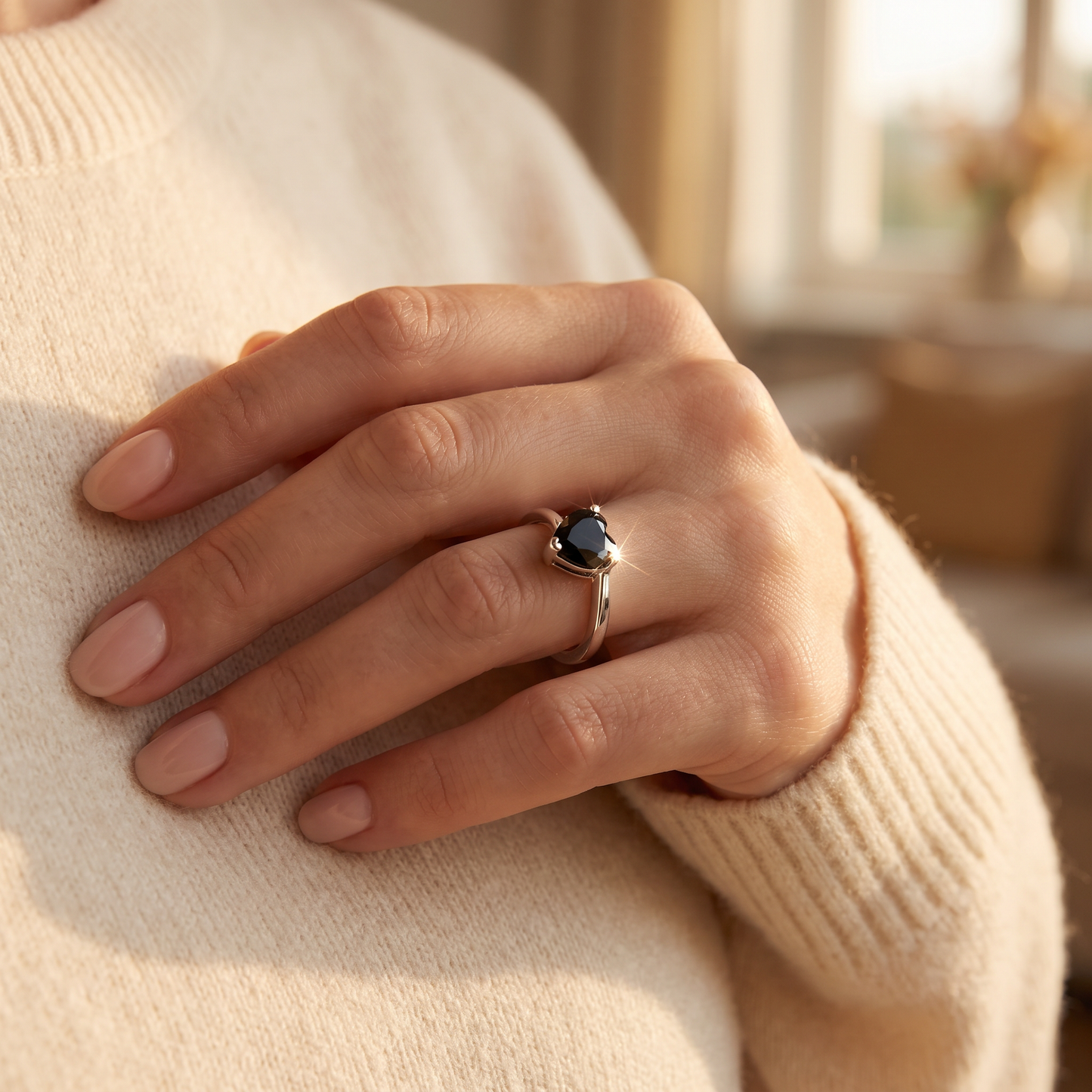 Sterling Silver Black Heart CZ Ring worn on a woman's hand in warm window light