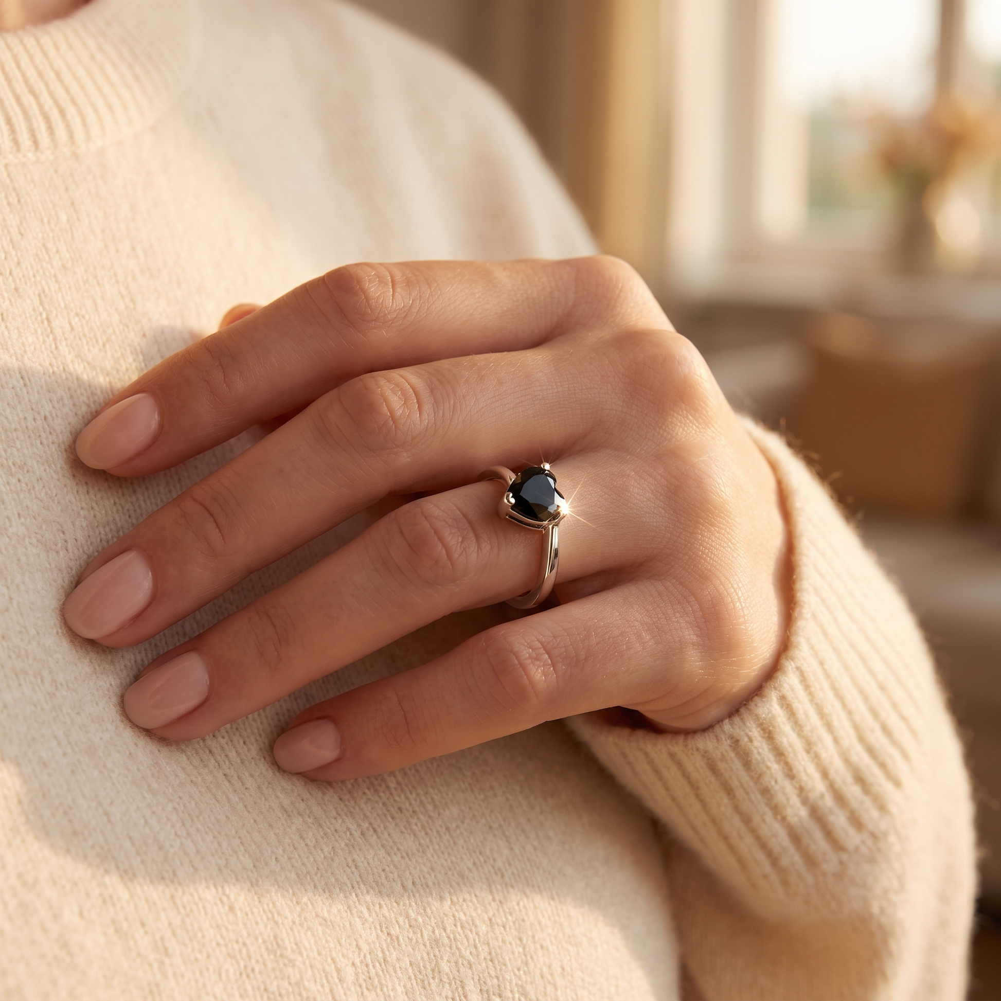 Sterling Silver Black Heart CZ Ring worn on a woman's hand in warm window light
