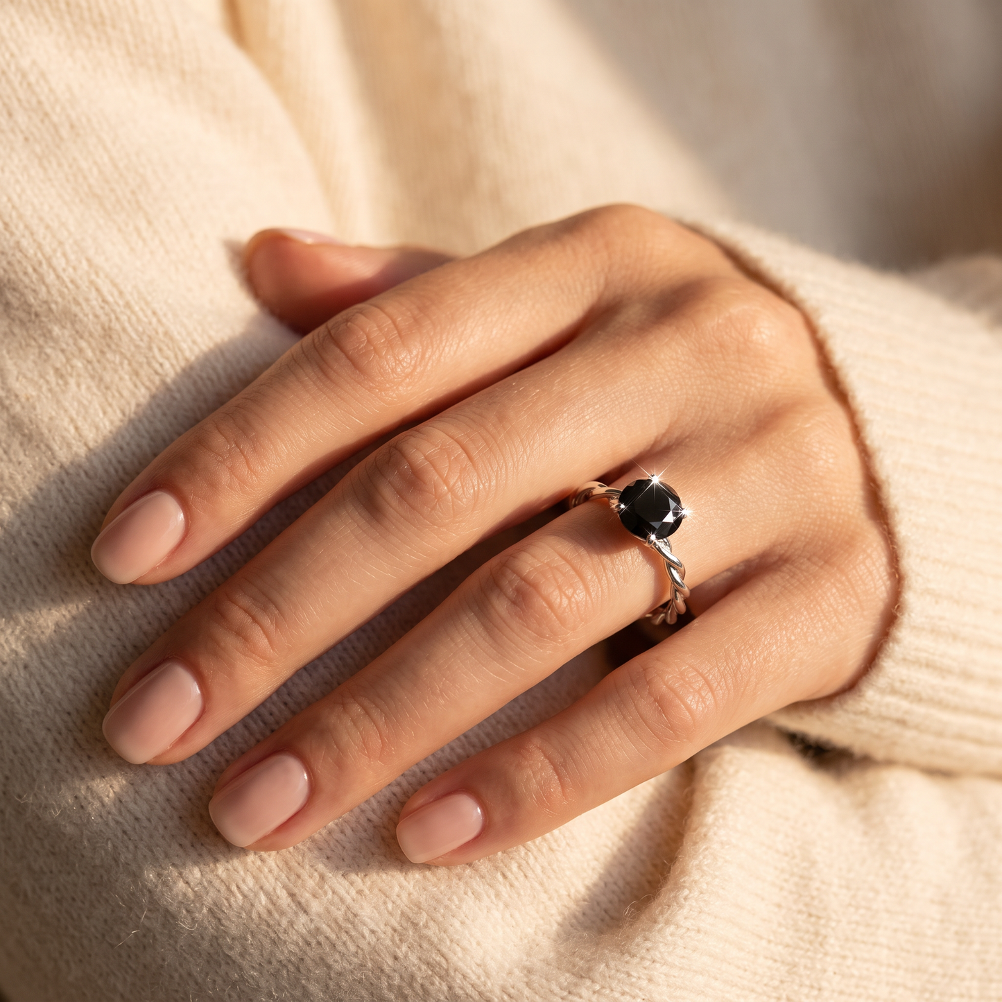 Sterling Silver Black Twisted Band CZ Ring worn on a woman's hand in warm window light