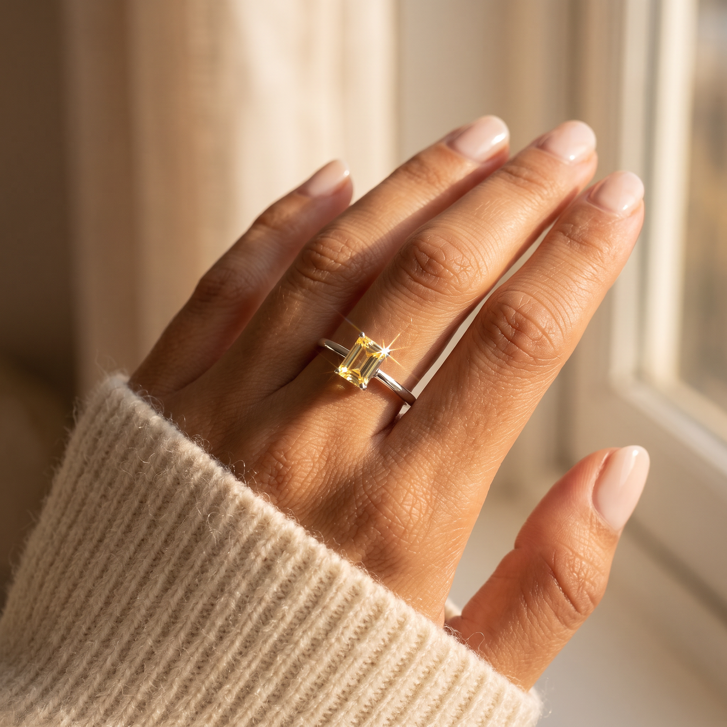 Sterling Silver Dainty Baguette Straight Yellow CZ Ring worn on a woman's hand in warm window light
