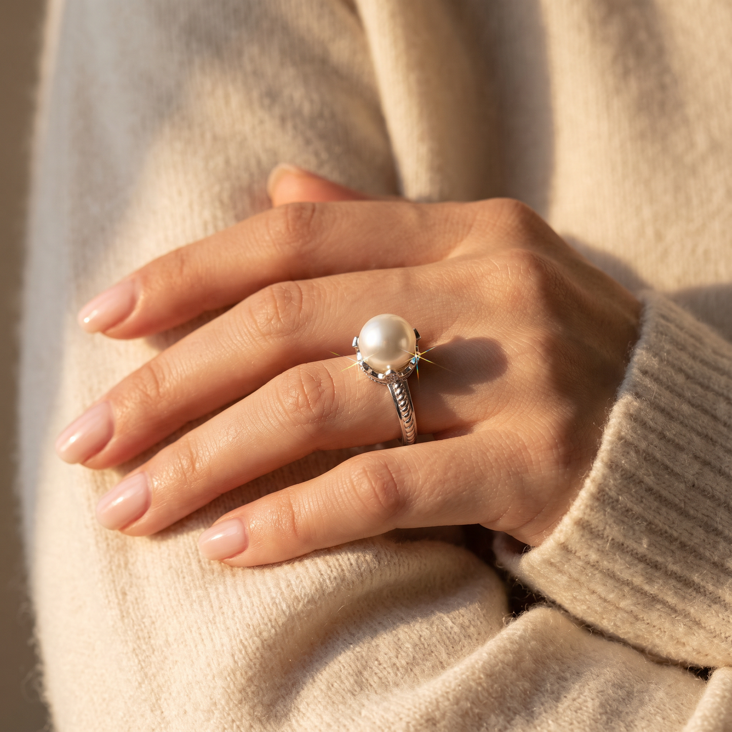 Sterling Silver King Crown Synthetic Pearl CZ Ring worn on a woman's hand in warm window light
