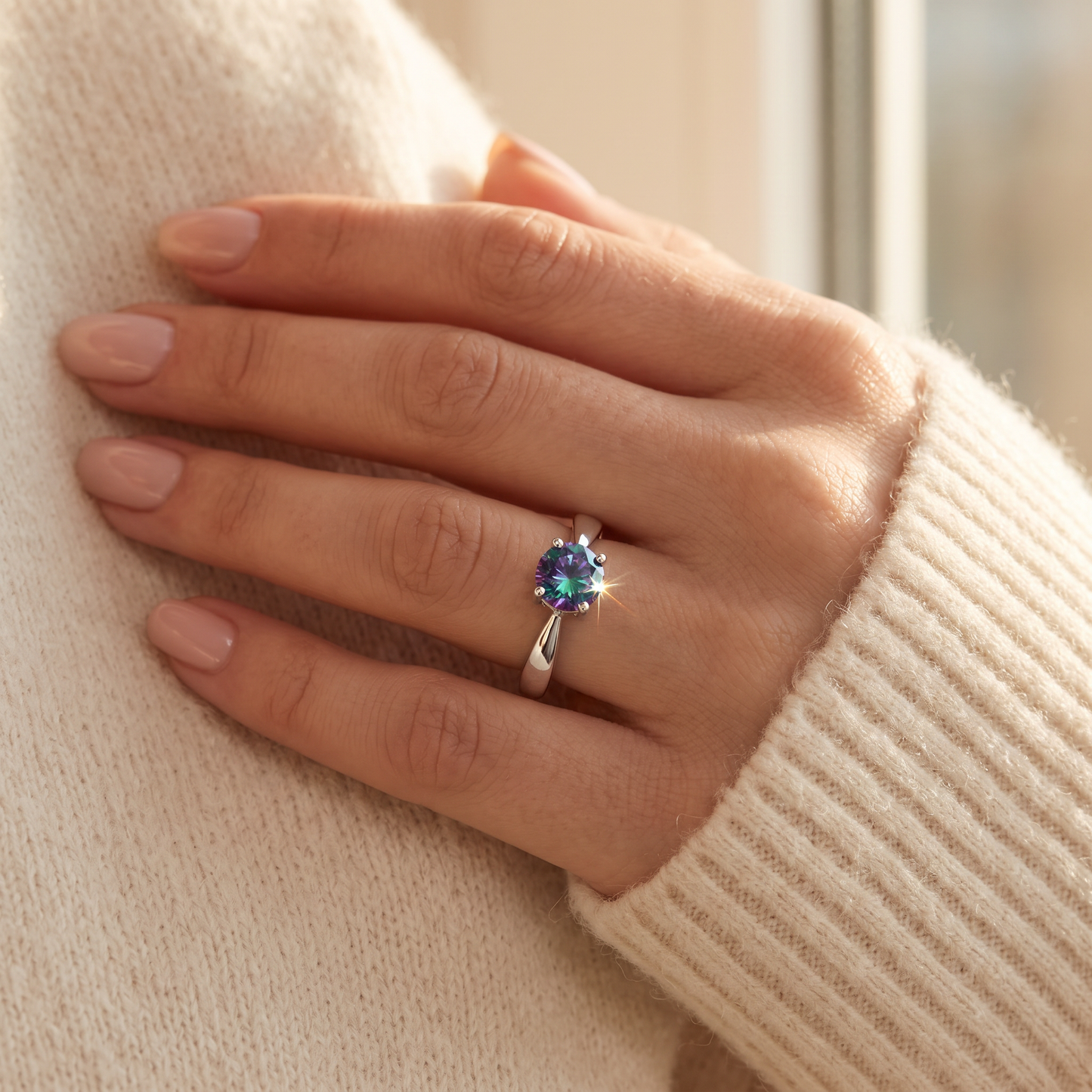 Sterling Silver 6mm Round Rainbow CZ Ring worn on a woman's hand in warm window light