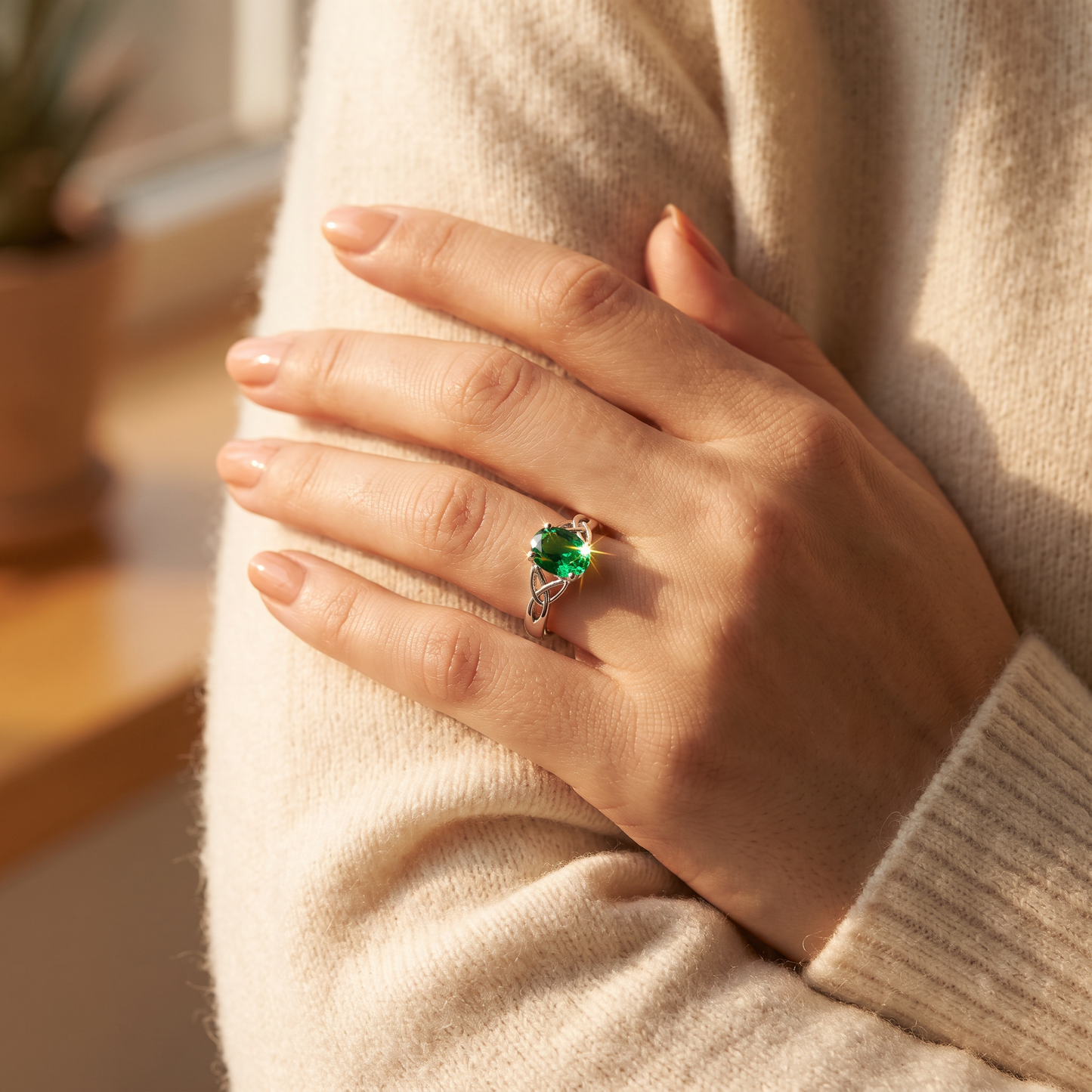 Sterling Silver Charmed Oval Green CZ Ring worn on a woman's hand in warm window light