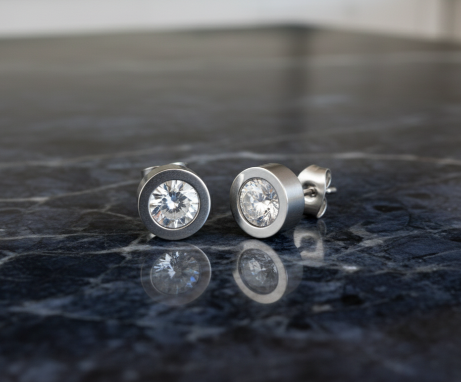 Pair of Steel Cz stud earrings on a dark marble surface