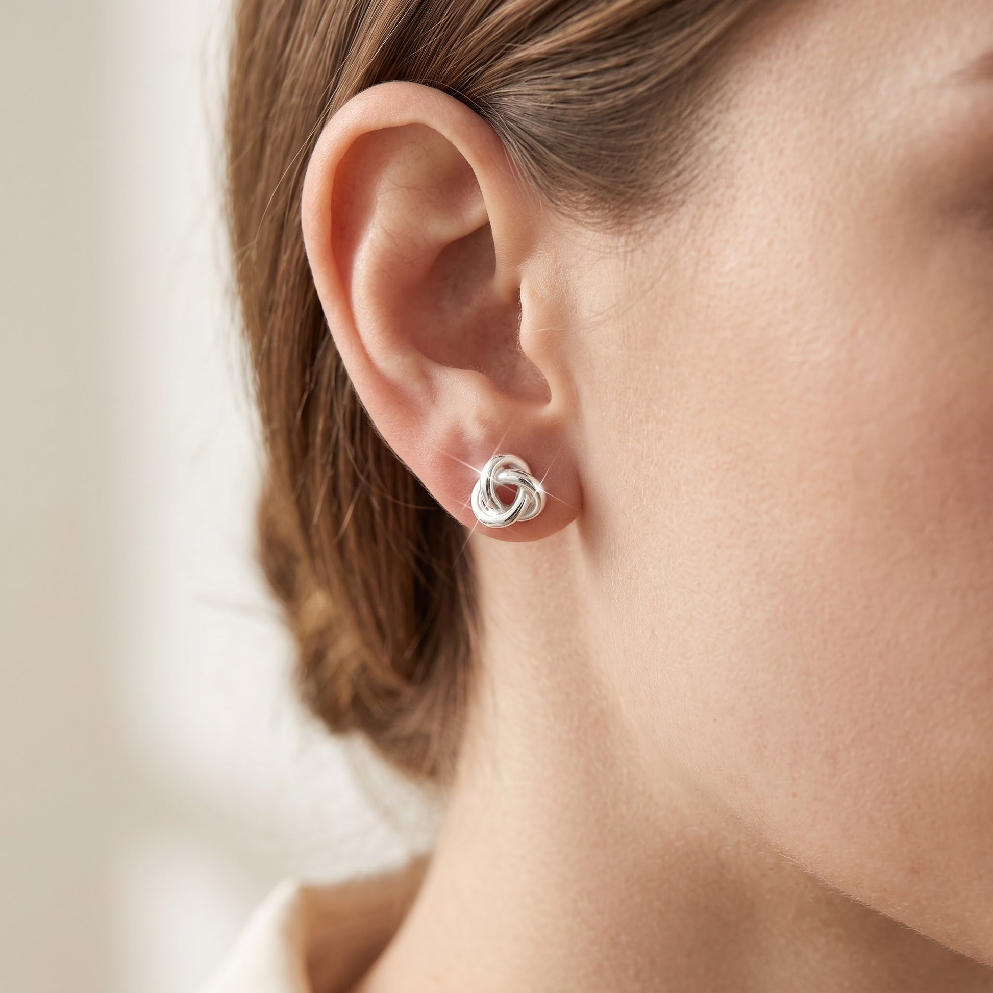 Sterling Silver Small Love Knot Women's stud Earrings Girls Love Knot Studs worn, lifestyle photo