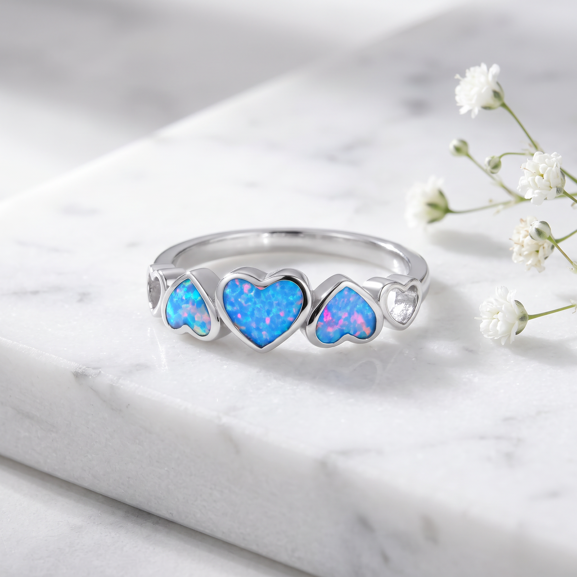 Sterling Silver Blue Lavender Lab Opal Sequence of Hearts Ring on marble