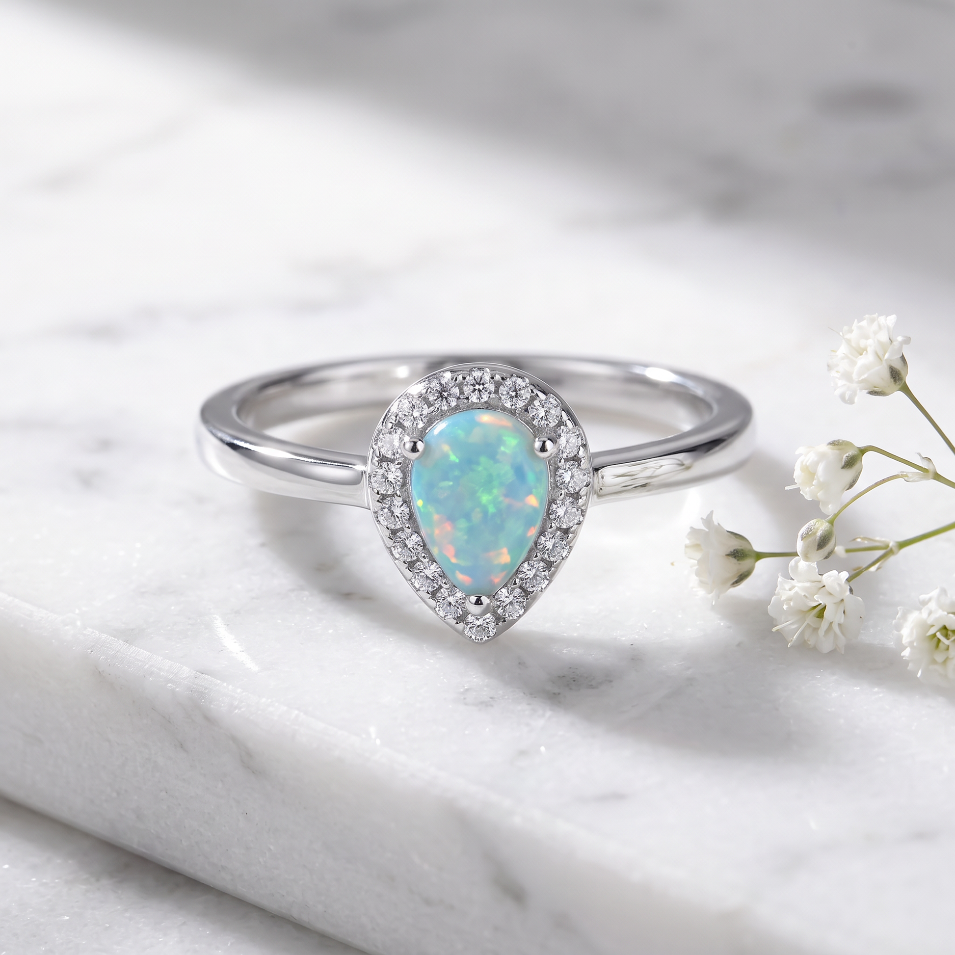 Sterling Silver White Lab Opal Tilted Pear Halo CZ Ring on marble