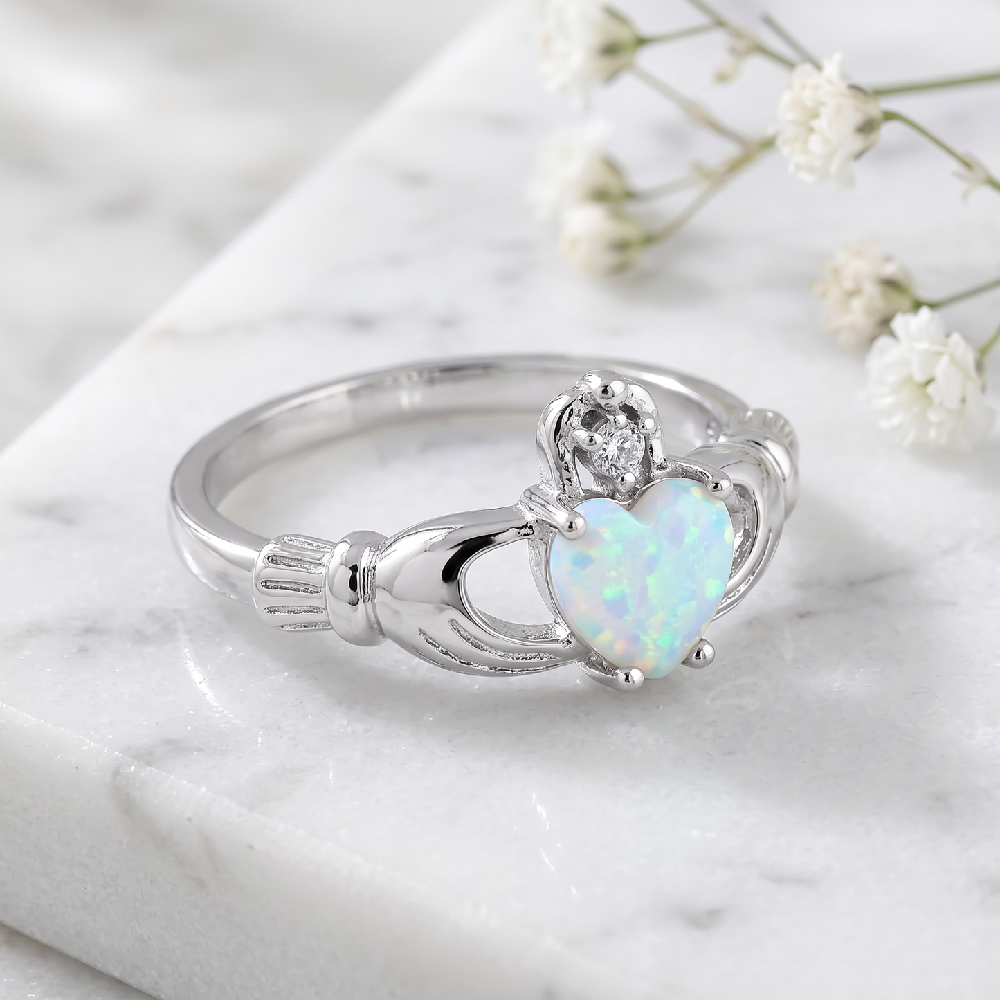 Sterling Silver Claddagh White Lab Opal CZ Ring on marble