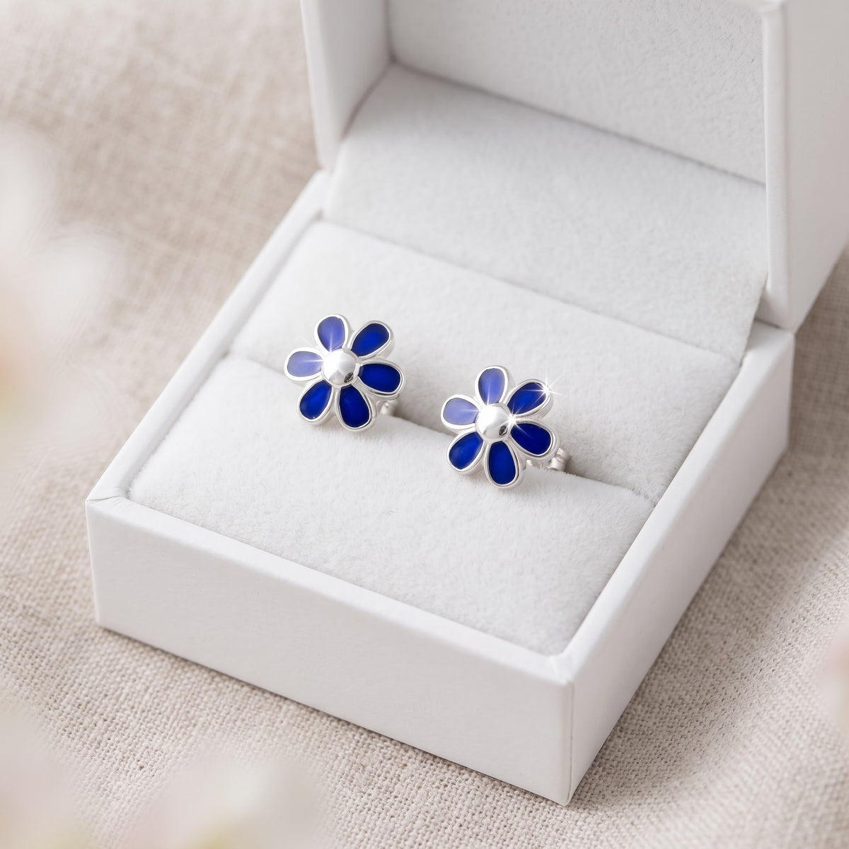 Sterling Silver Girls Dainty Blue Daisy Flower Stud Earrings in a white gift box, ready to give