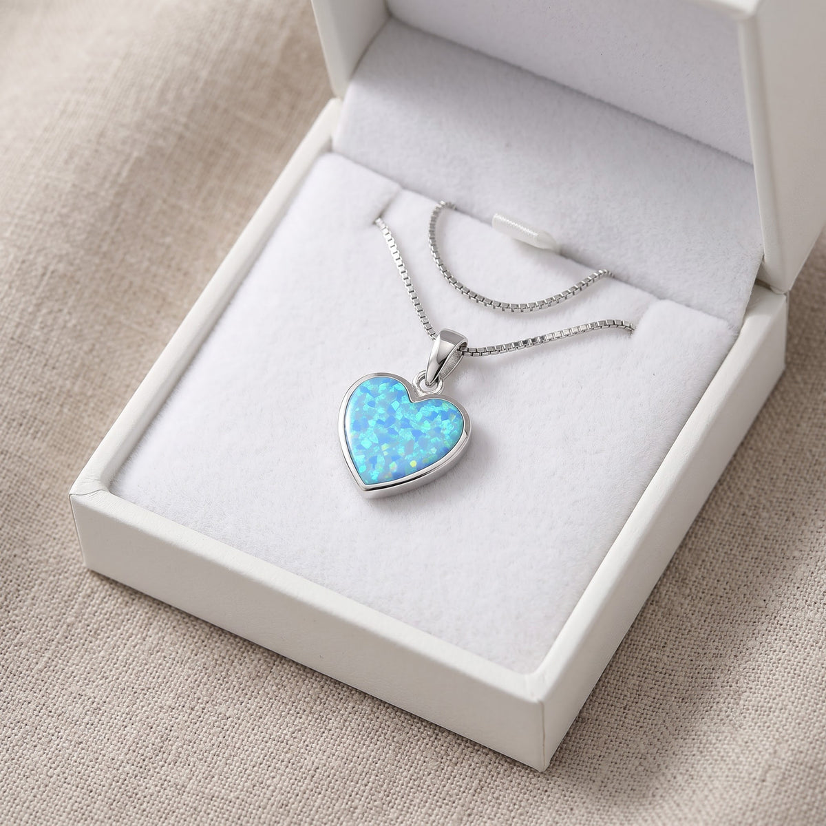 Sterling Silver Created Blue Opal Heart Necklace in a white gift box, ready to give