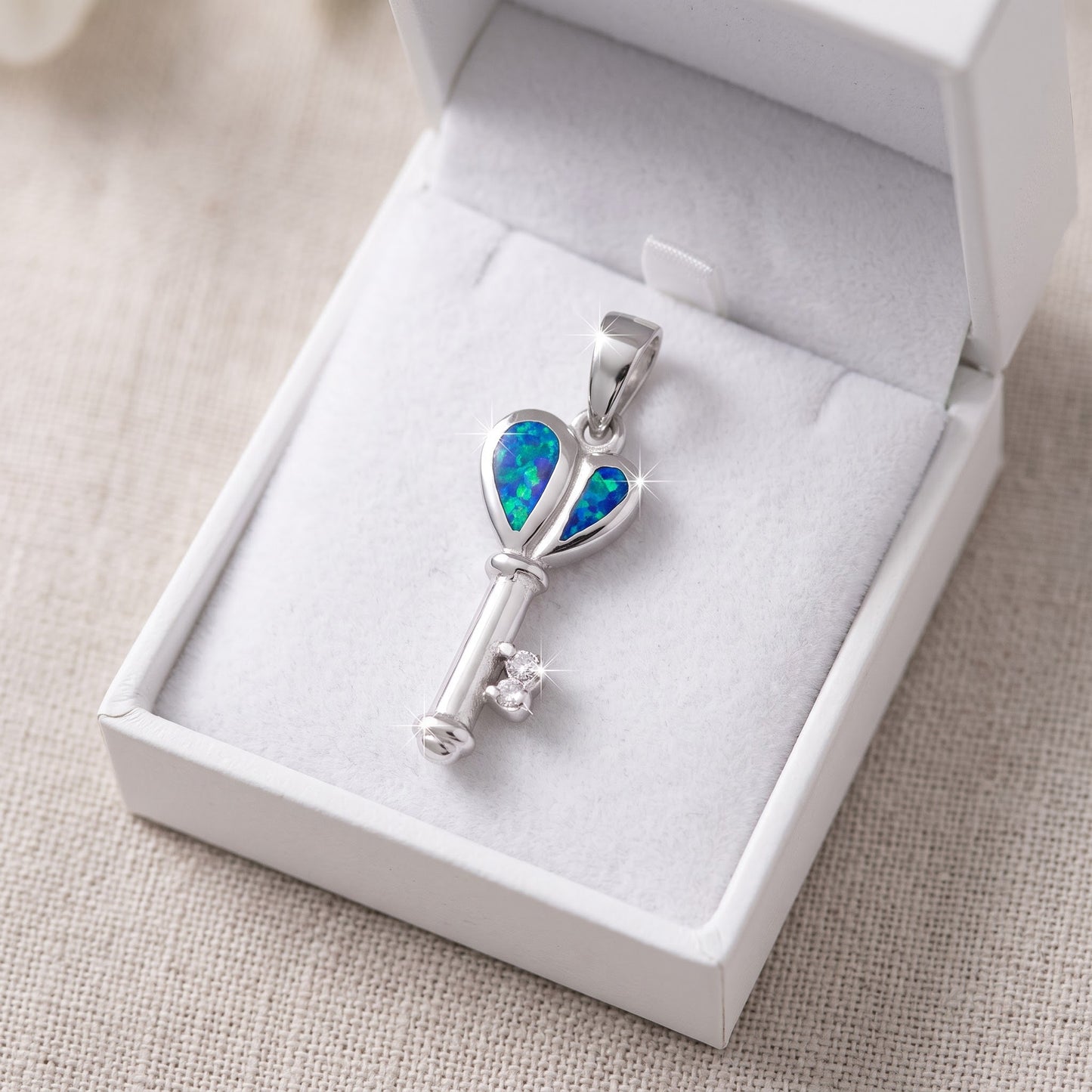 Sterling Silver CZ Created Blue Opal Heart Key necklace in a white gift box, ready to give