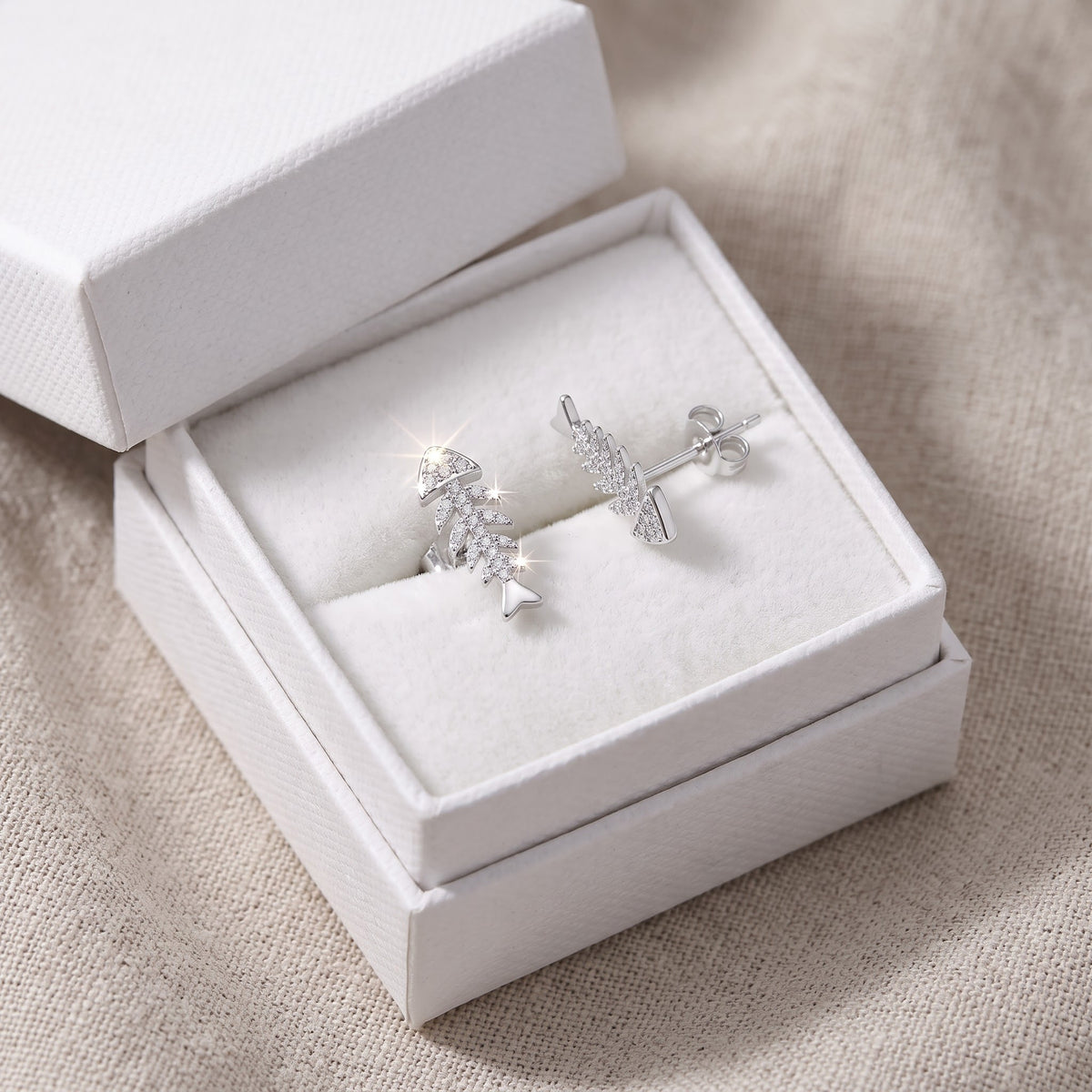 Sterling Silver CZ Fish Bone Stud Earrings in a white gift box, ready to give