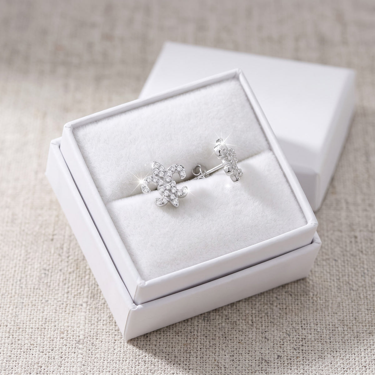 Sterling Silver CZ Fleur De Lis Stud Earrings in a white gift box, ready to give