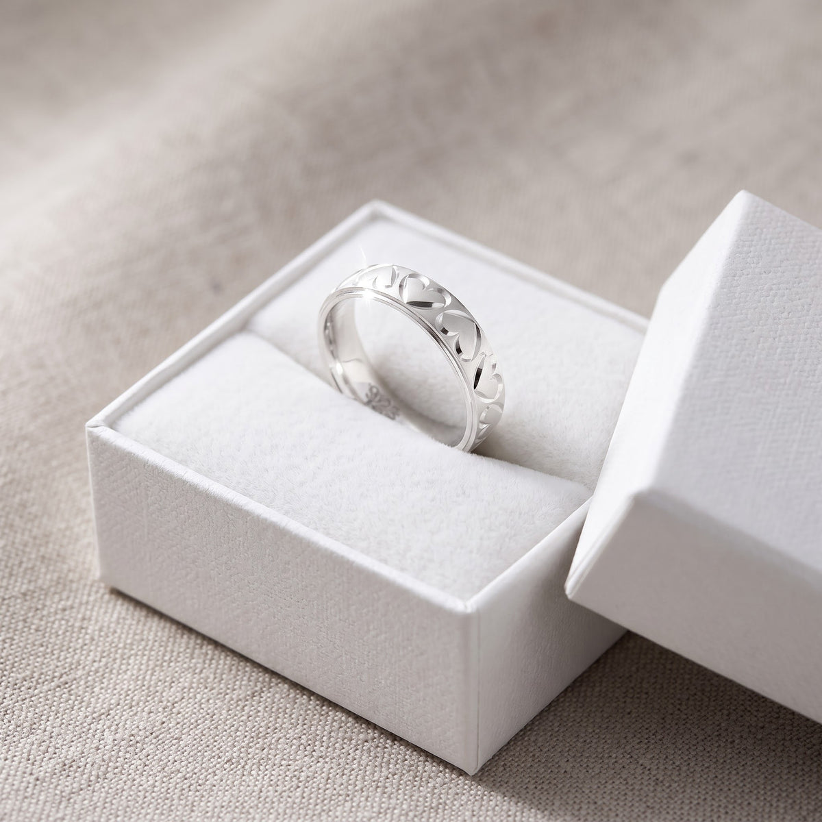 Sterling Silver Diamond Cut Heart Wedding Band Ring in a white gift box, ready to give
