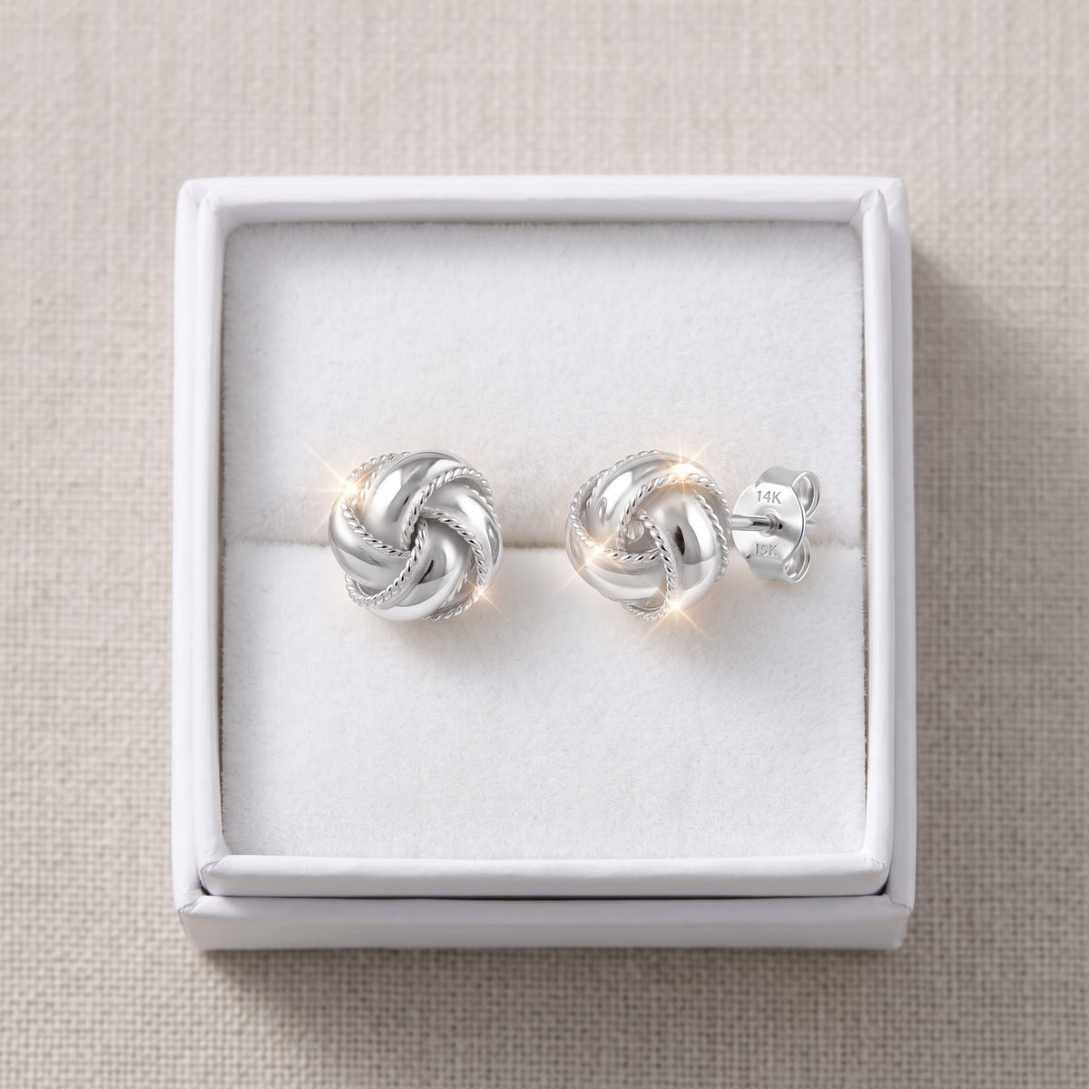 Sterling Silver Women's Dainty Love Knot Stud Earrings in a white gift box, ready to give