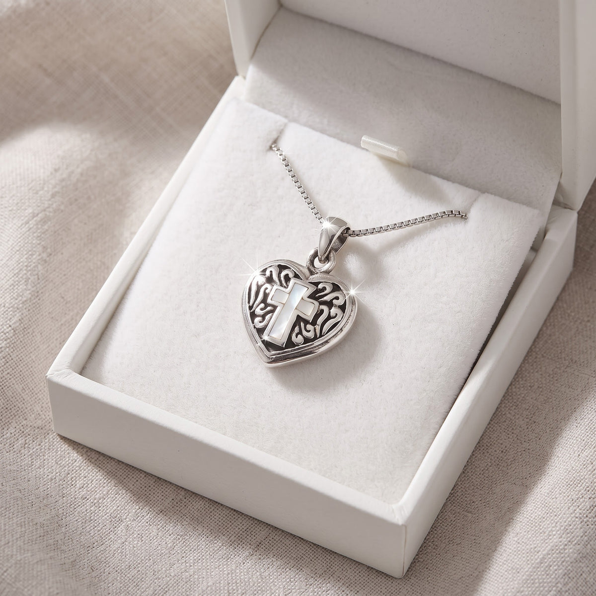 Sterling Silver Mother Of Pearl Cross Heart Necklace in a white gift box, ready to give