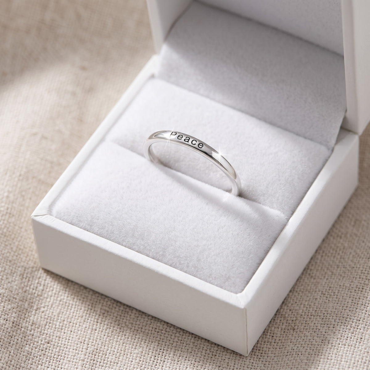 Sterling Silver Thin Stackable Peace Ring in a white gift box, ready to give
