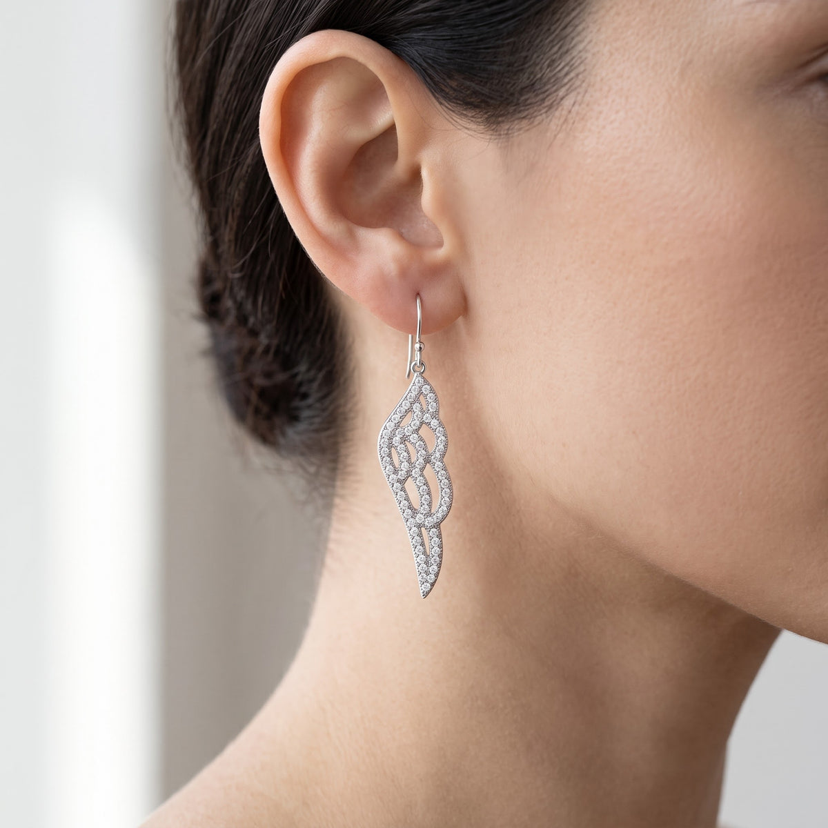 White Gold over Sterling Silver Women's CZ Angel Wing Dangle Earrings worn, lifestyle photo