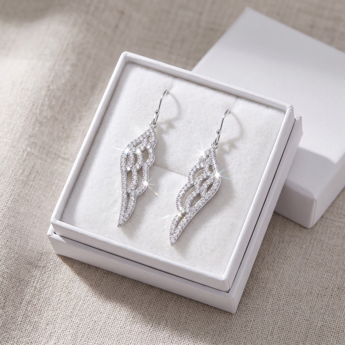 White Gold over Sterling Silver Women's CZ Angel Wing Dangle Earrings in a white gift box, ready to give
