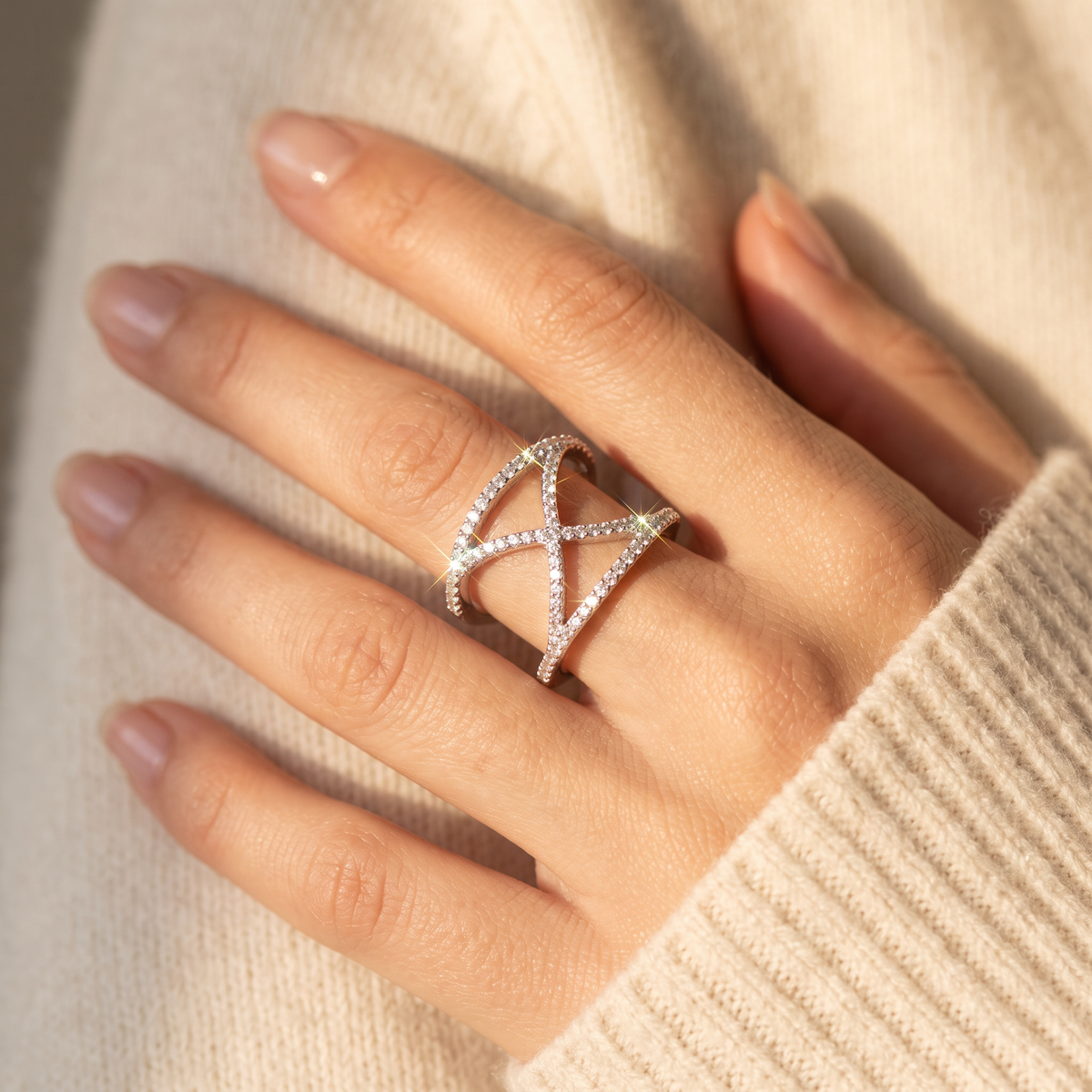 White Gold over Sterling Silver Ladies Wide X CZ Statement Ring worn on a woman's hand in warm window light