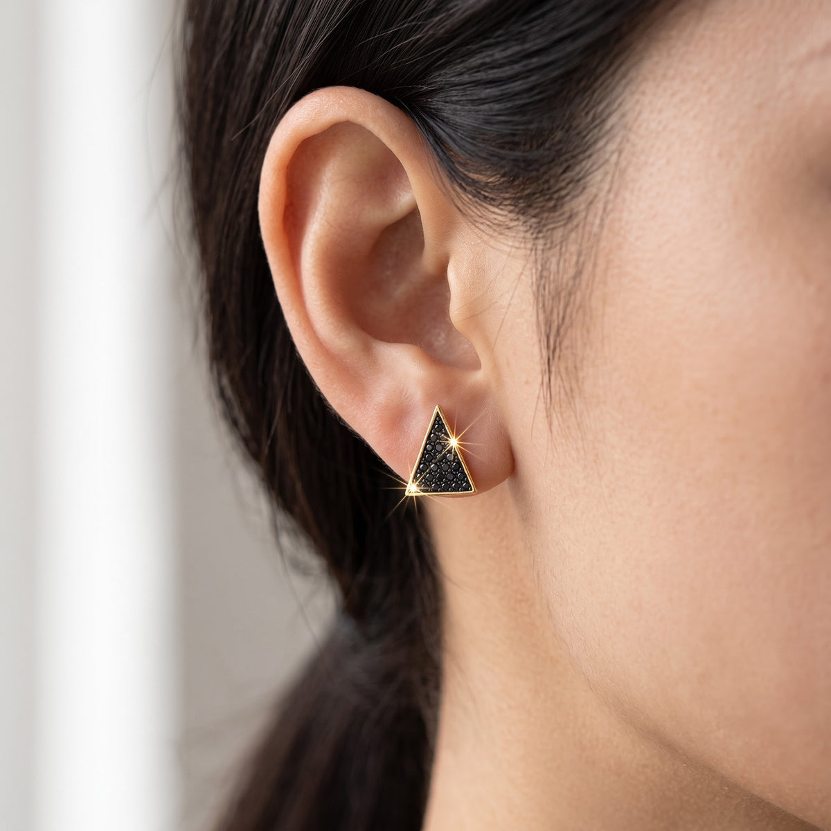 Yellow Gold over Sterling Silver Women's Black CZ Triangle Stud Earrings worn, lifestyle photo